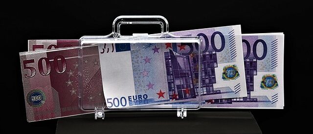 Läpinäkyvä matkalaukku, jonka läpi näkyy euro-seteleitä.