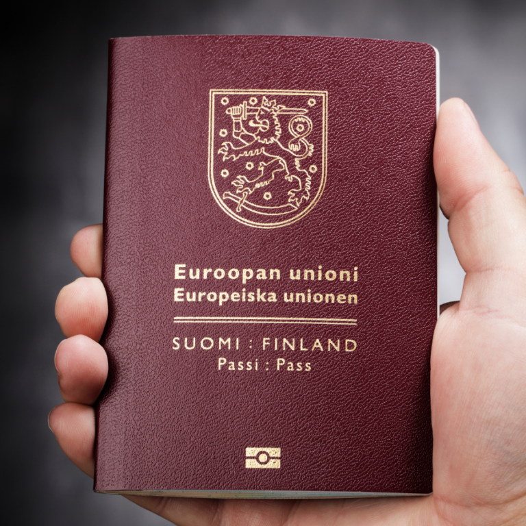 Henkilö pitää kädessään Suomen passia. Tausta on sumennettu harmaa.