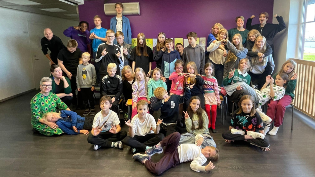 Tallinnan suomalaisen koulun oppilaat ja aikuiset koulun yhteisessä toimintahetkessä sisätiloissa.